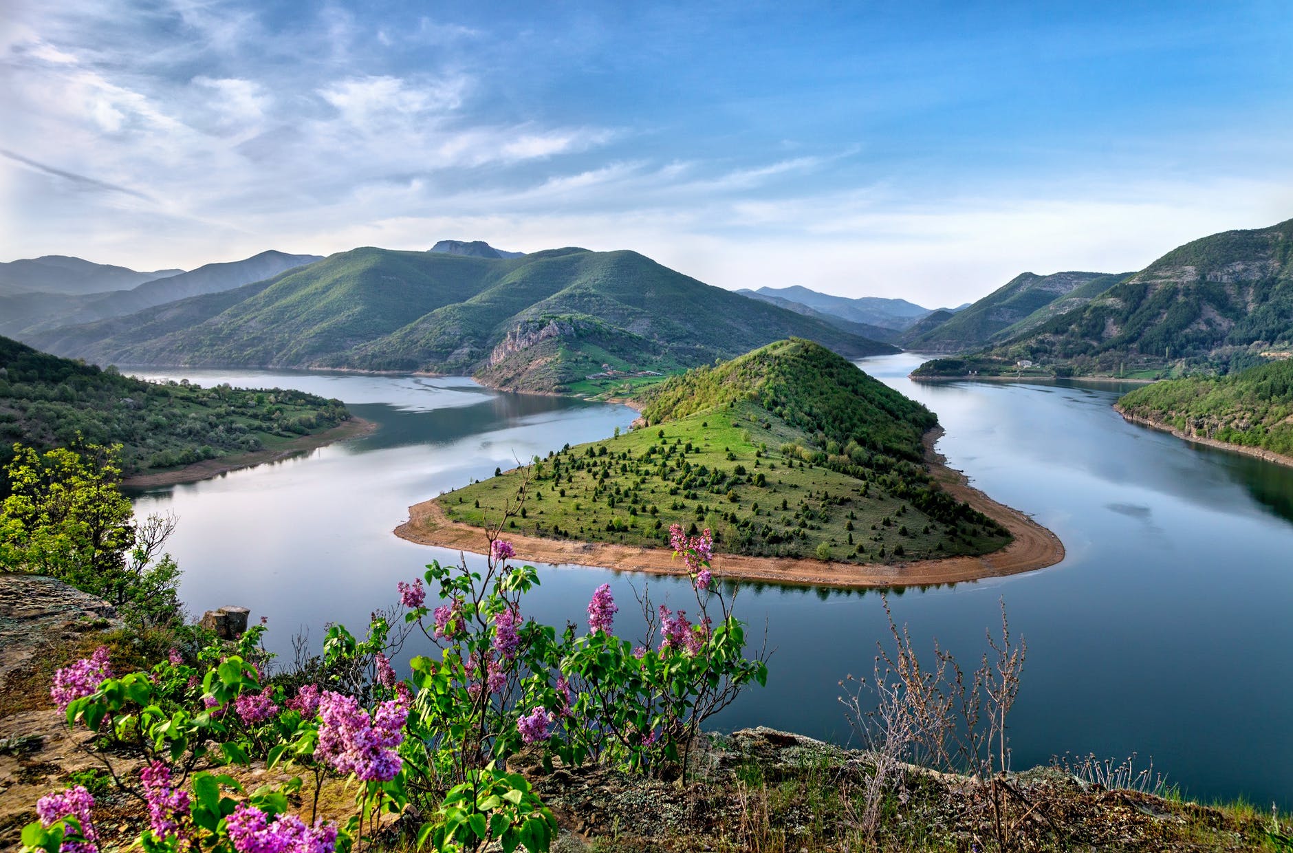 green mountain surrounded by body of water photo